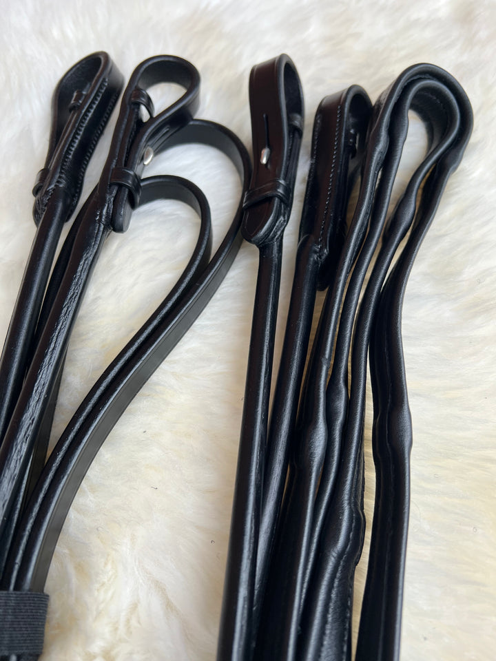 Ein Set schwarze, rundgenähte Kandaren-Softzügel PERFECTION mit verdeckter Dornschnalle.