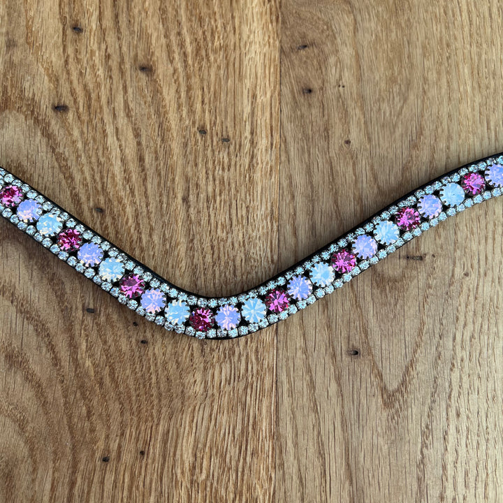 Ein glanzvoller Stirnriemen mit Qualitätssteinen der Marke Preciosa aus einer Kombination mit kräftigem Pink, sanftem Rosa und weißem Opal.